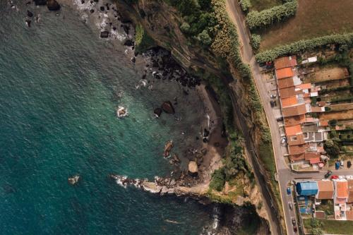 an aerial view of a beach with houses and the water at The Blue House Azores in Capelas