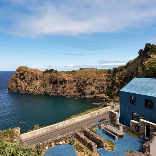 a blue house on a cliff next to the ocean at The Blue House Azores in Capelas