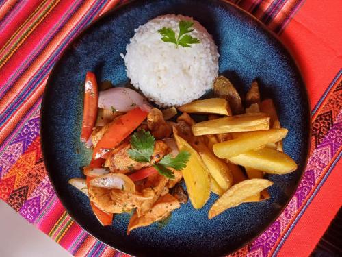 a blue plate of food with rice and vegetables at Hotel La Posada de Atahualpa in Cusco