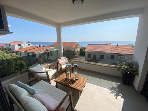 a balcony with a couch and a view of the ocean at Clear Water Apartment - Seaside in Mandre
