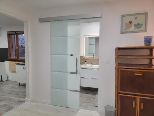 une porte coulissante en verre dans une cuisine avec un réfrigérateur dans l'établissement Séjour détente pour toute la famille, à Martigues