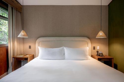 a bedroom with a bed with two night stands and two lamps at Senda Monteverde Hotel Member of the Cayuga Collection in Monteverde Costa Rica