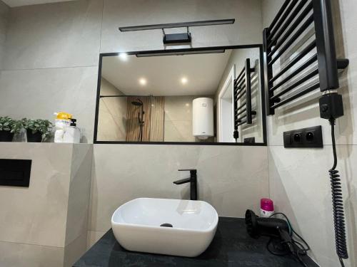 a bathroom with a white sink and a mirror at Biały Domek Świerczek in Słopnice