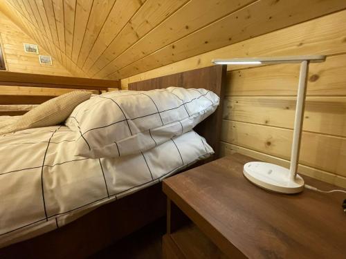 a bedroom with a bed and a desk with a lamp at Biały Domek Świerczek in Słopnice