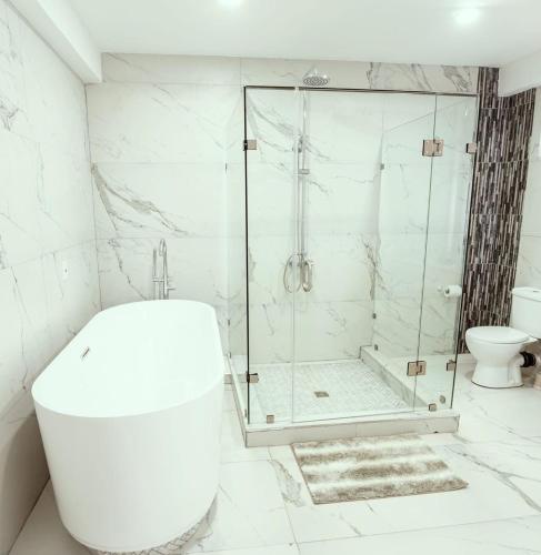 a white bathroom with a shower and a toilet at Maximum Beach Hotel in Corozal