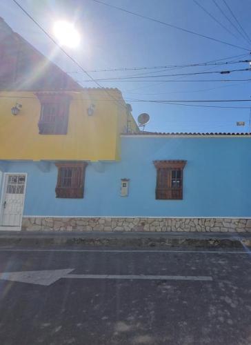 a blue and yellow building with windows on a street at Hospedaje El Encanto in Zipaquirá