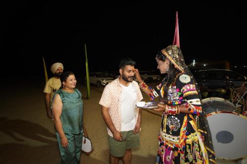 a man and a woman standing next to a drum at Royal Adventure Jaisalmer Resort in Jaisalmer