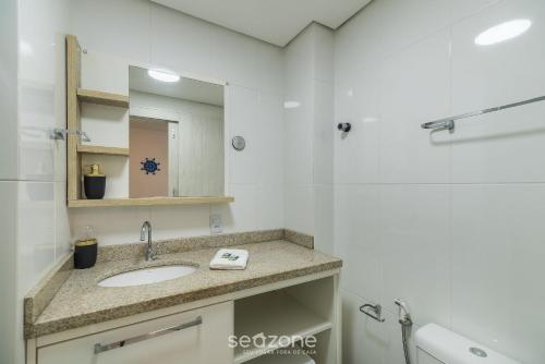 a bathroom with a sink and a mirror at Apto c/ Churrasqueira 450m da Praia PNM0202 in Florianópolis