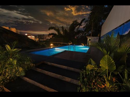 a swimming pool in the middle of a yard at Holidays Garden Resort in Kalpetta