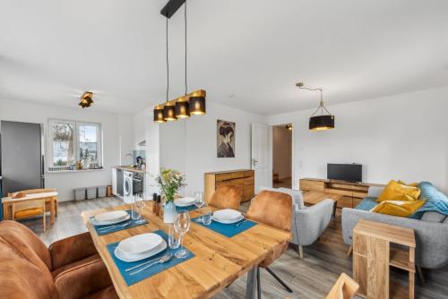 a living room with a table and a couch at Familienfreundliches Apartment zwischen Potsdam und Berlin für 2-4 Personen - Parkplatz - Balkon - Voll ausgestattete Küche - WLAN - Ferienwohnung Nebelwiesen Stahnsdorf in Stahnsdorf