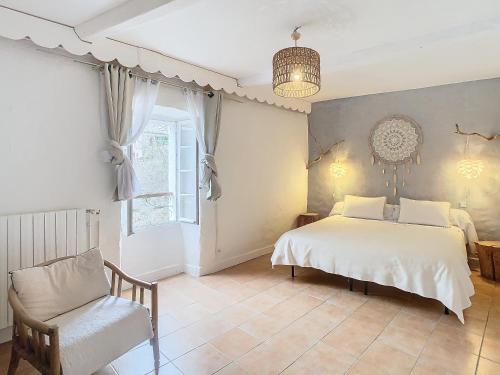 a bedroom with a bed and a chair and a window at la source fraiche in Notre-Dame-de-la-Rouvière