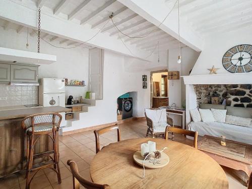 a kitchen and a living room with a wooden table at la source fraiche in Notre-Dame-de-la-Rouvière