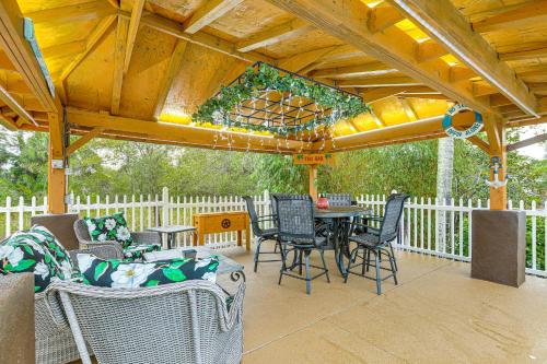 River ParkにあるRiverfront House in Port St Lucie with Pool and Dock!の木製の屋根の下にテーブルと椅子付きのパティオ