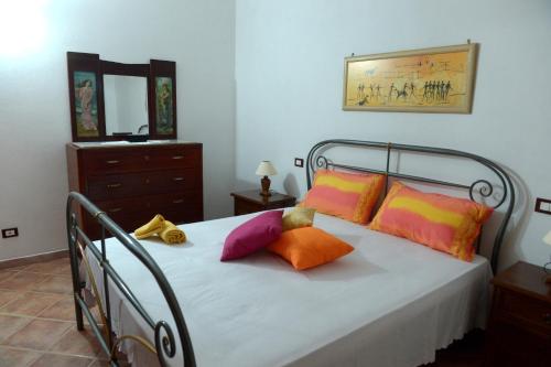 ein Schlafzimmer mit einem Bett mit bunten Kissen darauf in der Unterkunft Villa Pergola in San Michele Salentino