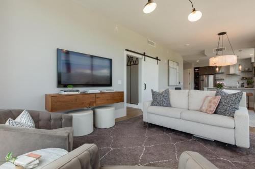 a living room with two couches and a flat screen tv at Panoramic Pack Square | Arras Vacation Rentals in Chalet Village