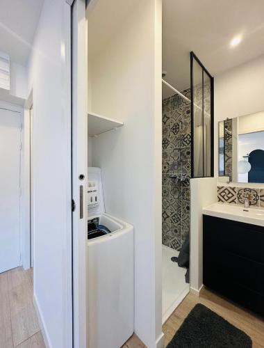 La salle de bains est pourvue de murs blancs, d'un lavabo et d'un miroir. dans l'établissement Le Mystique #Rénové Centre Ville, à Cognac