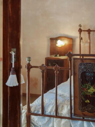 a bed with a wooden frame and a lamp on a table at Borgoterra in Martano