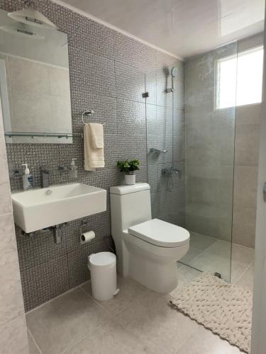 a bathroom with a toilet and a sink and a shower at Santo Domingo Este Stylish Condo in San Isidro