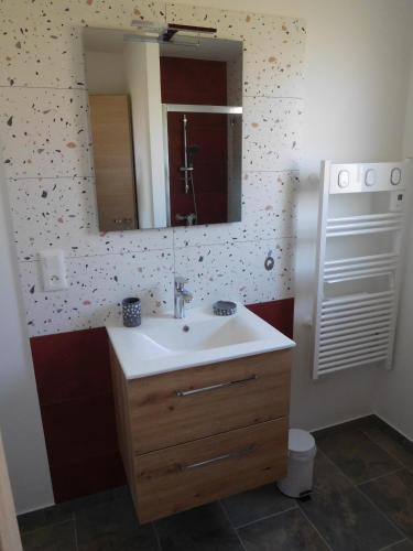 une salle de bain avec un lavabo et un miroir dans l'établissement La CHANTERELLE, à Mortagne