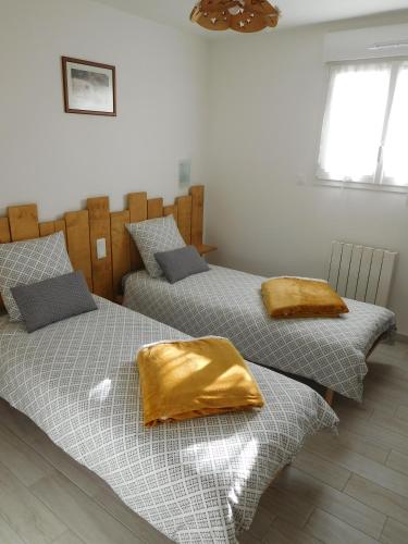 deux lits côte à côte dans une chambre dans l'établissement La CHANTERELLE, à Mortagne