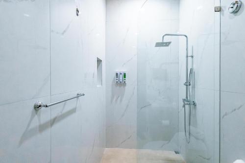 a shower with a glass door in a bathroom at Mountain Top Park Hotel in Quepos