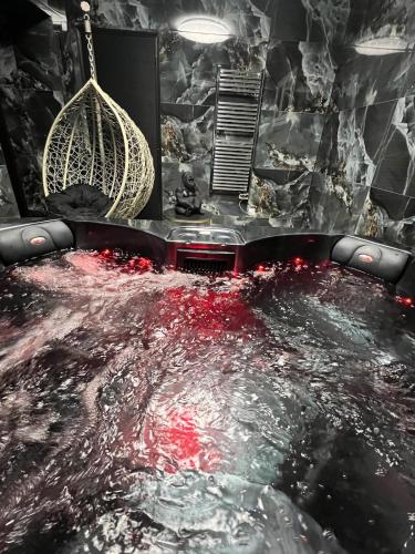 une baignoire remplie d'eau dans une pièce dans l'établissement La Villa Dorée & SPA Netflix Parking Wifi, à Kurtzenhouse