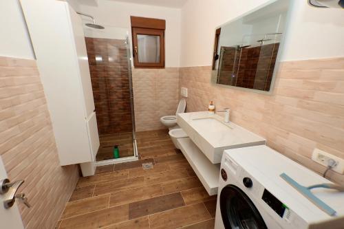 a bathroom with a sink and a washing machine at Livinn Apartments-Superior Apartment in Prizren
