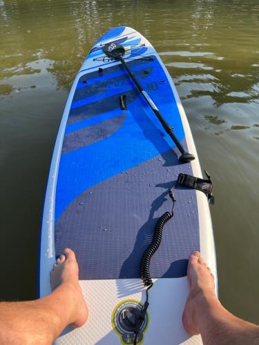 a man sitting on a paddle board in the water at Brīvdienu māja Skerškāni in Krāslava
