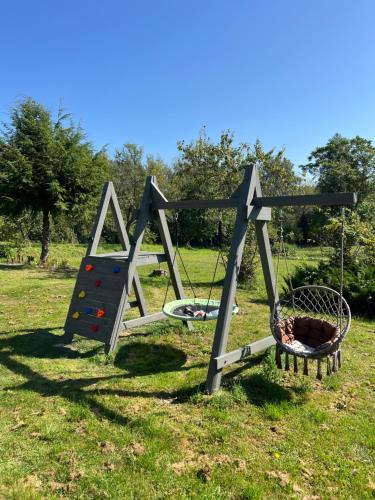 an outdoor playground with a swing and a basket at Brīvdienu māja Skerškāni in Krāslava