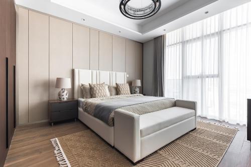 a bedroom with a large bed and a window at Simply Comfort Vacation Homes Rental Apartments at Nobles Tower Luxury Burj View in Dubai
