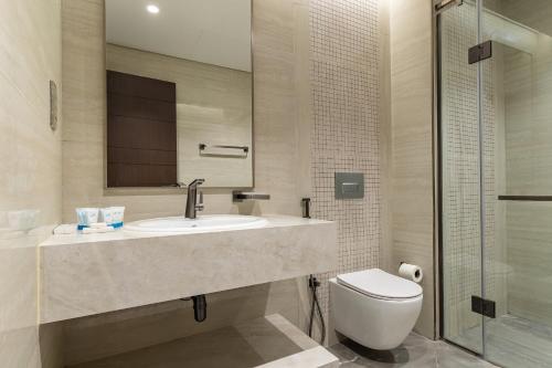 a bathroom with a sink and a toilet at Simply Comfort Vacation Homes Rental Apartments at Nobles Tower Luxury Burj View in Dubai