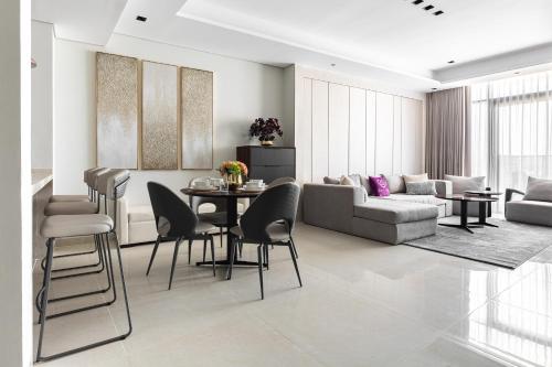 a living room with a table and chairs and a couch at Simply Comfort Vacation Homes Rental Apartments at Nobles Tower Luxury Burj View in Dubai