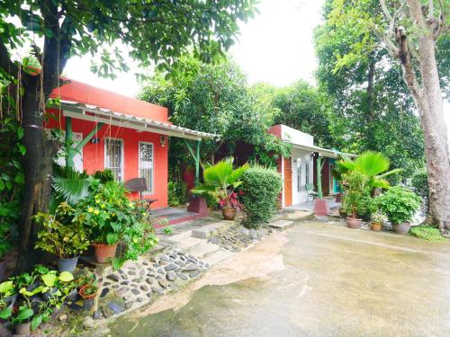 a red house with potted plants in front of it at Forest Bungalows & Mama's Restaurant in Chalong
