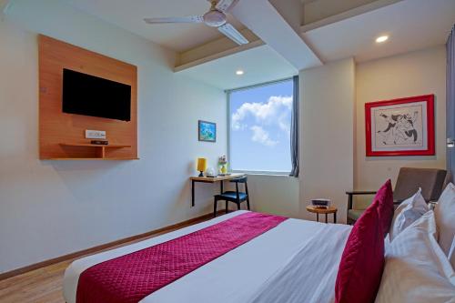 a bedroom with a large bed and a tv at Hotel Aerostar Grand at Yashobhoomi Convention Center in New Delhi