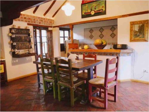 une cuisine avec une table et des chaises dans une pièce dans l'établissement Villa exclusiva con jardín a 80m del centro, à Villa de Leyva