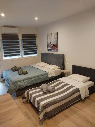 two beds sitting in a room with windows at AniBo Studios & Apartments center 3861 in Thessaloniki