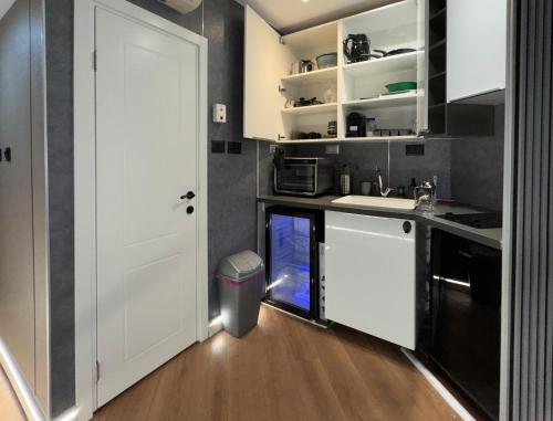 a kitchen with white cabinets and a white door at קו המים-אמבט ספא במרפסת על הים, בית קפה בלובי Waterline studio sea view Spa tub on the balcony in Netanya