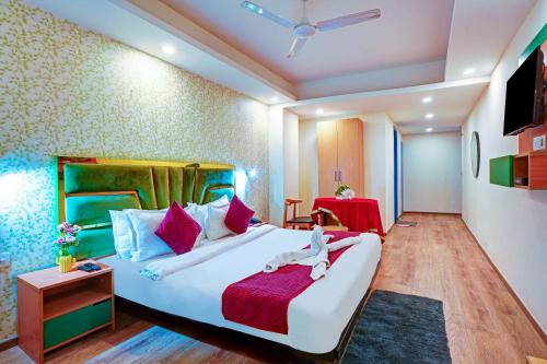 a bedroom with a large white bed with a red blanket at Hotel Aerostar Grand at Yashobhoomi Convention Center in New Delhi