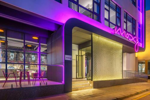 a building with a purple neon sign on it at Moxy Suzhou City Centre in Suzhou