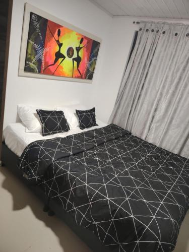 a bedroom with a bed with a black comforter at Aparta estudio amoblado en Chinchiná Caldas Eje Cafetero in Chinchiná