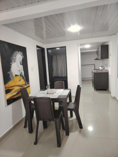a dining room with a table and a painting of a horse at Aparta estudio amoblado en Chinchiná Caldas Eje Cafetero in Chinchiná