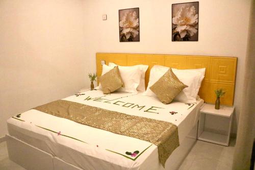 a bedroom with a bed with a welcome sign on it at Sea Sun Stay in Maafushi