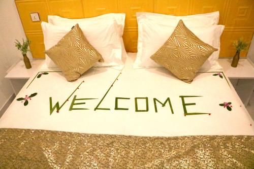 a bed with the words welcome written on it at Sea Sun Stay in Maafushi