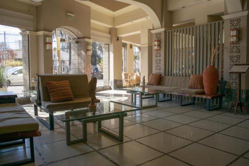 a lobby with couches and tables on a tiled floor at Hotel Inkai in Salta