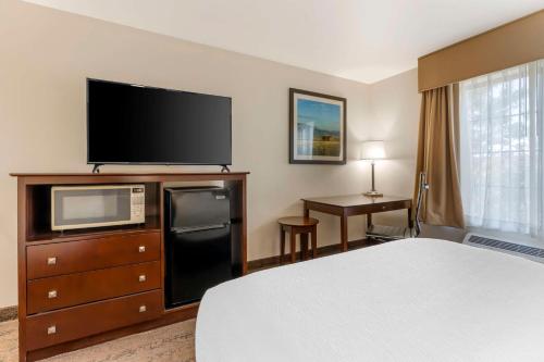a hotel room with a bed and a flat screen tv at Best Western Yellowstone Crossing in Laurel