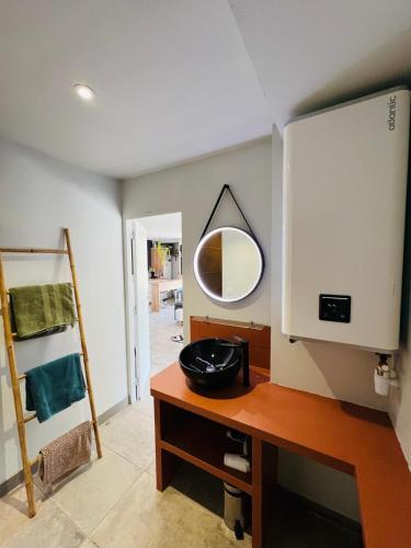 La salle de bains est pourvue d'un miroir sur un comptoir en bois. dans l'établissement Piscine chauffée dans les vignes, à Roquefort-la-Bédoule