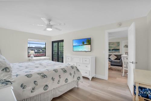 a white bedroom with a bed and a living room at Updated and Beautiful Views in Naples