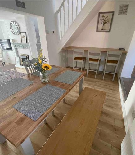a living room with a wooden table and chairs at Cozy two bedroom home with historic significance in Saint Neots