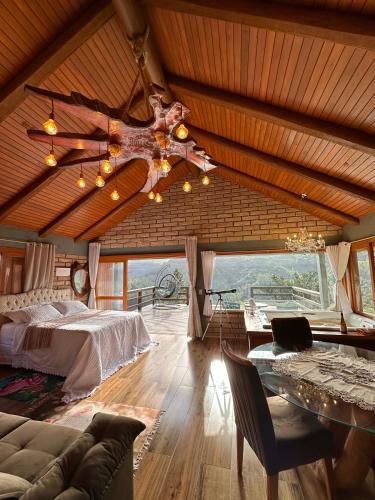 a bedroom with a bed and a table in a room at Chalé 2 - Cordilheira Dos Canyons in Praia Grande