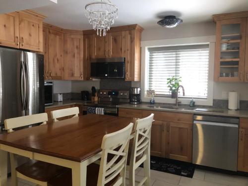 a kitchen with a wooden table with white chairs at Simcoe B&B - Incredible vacation suite in Smithers